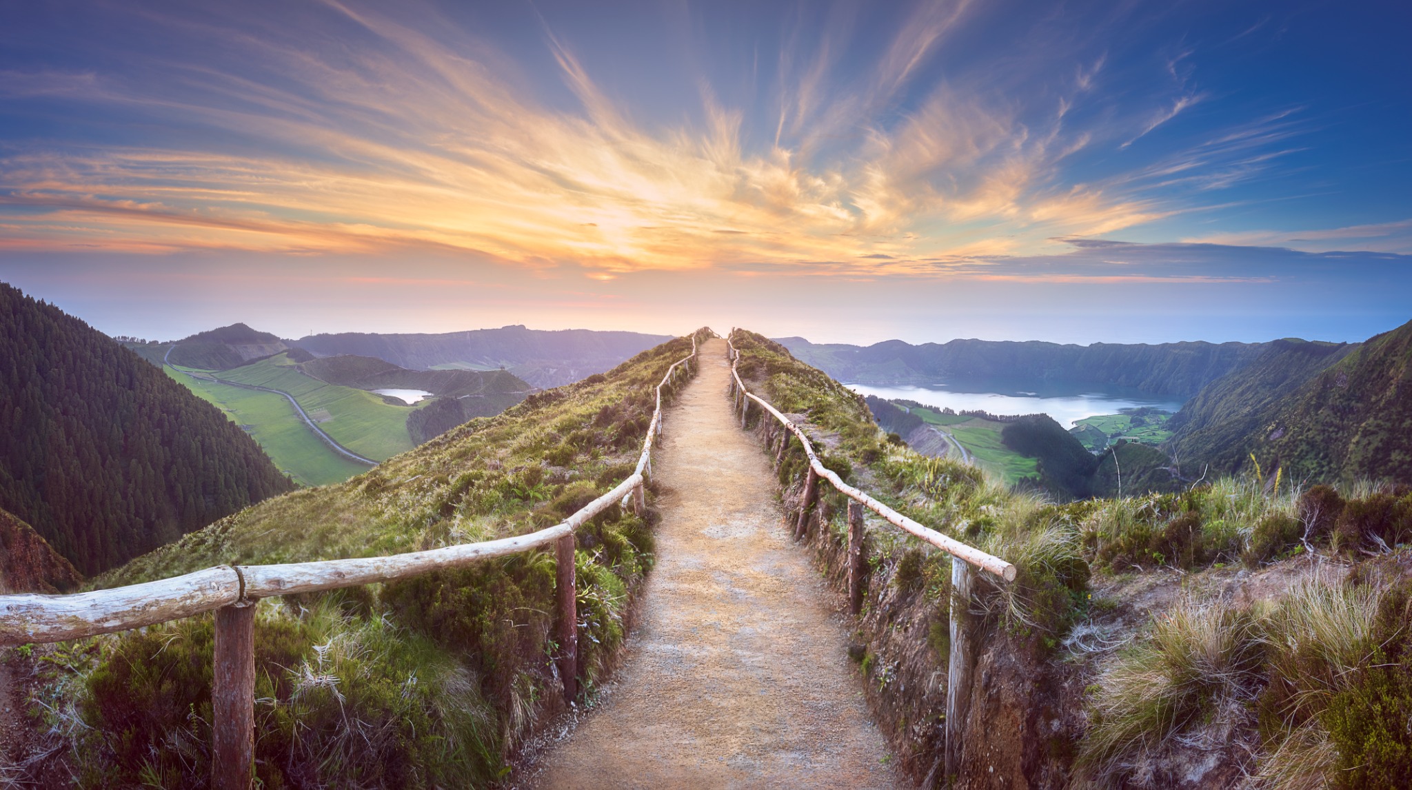 A mountain path leading toward a radiant horizon